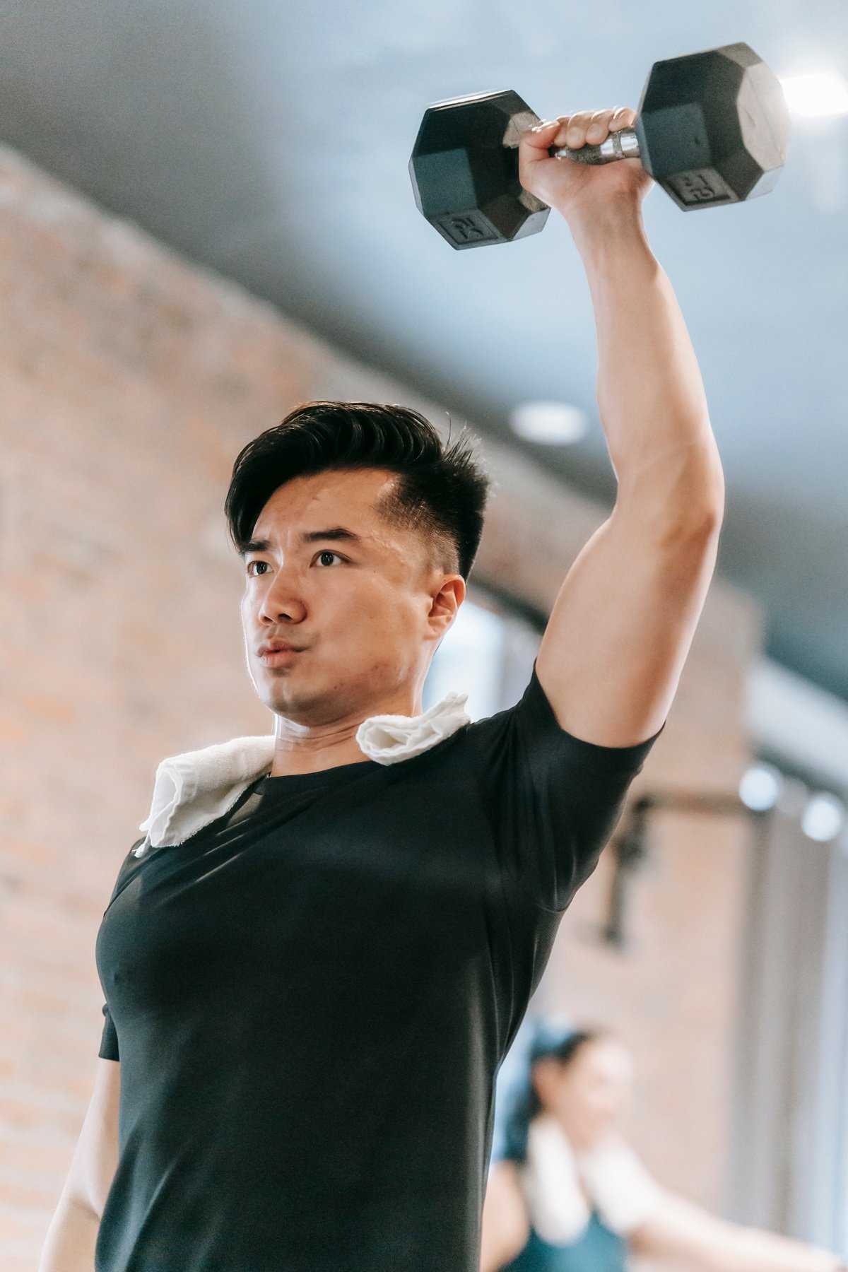 Asian man lifting heavy weight in gym